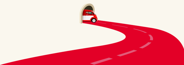 Red bus emerging from tunnel to winding road